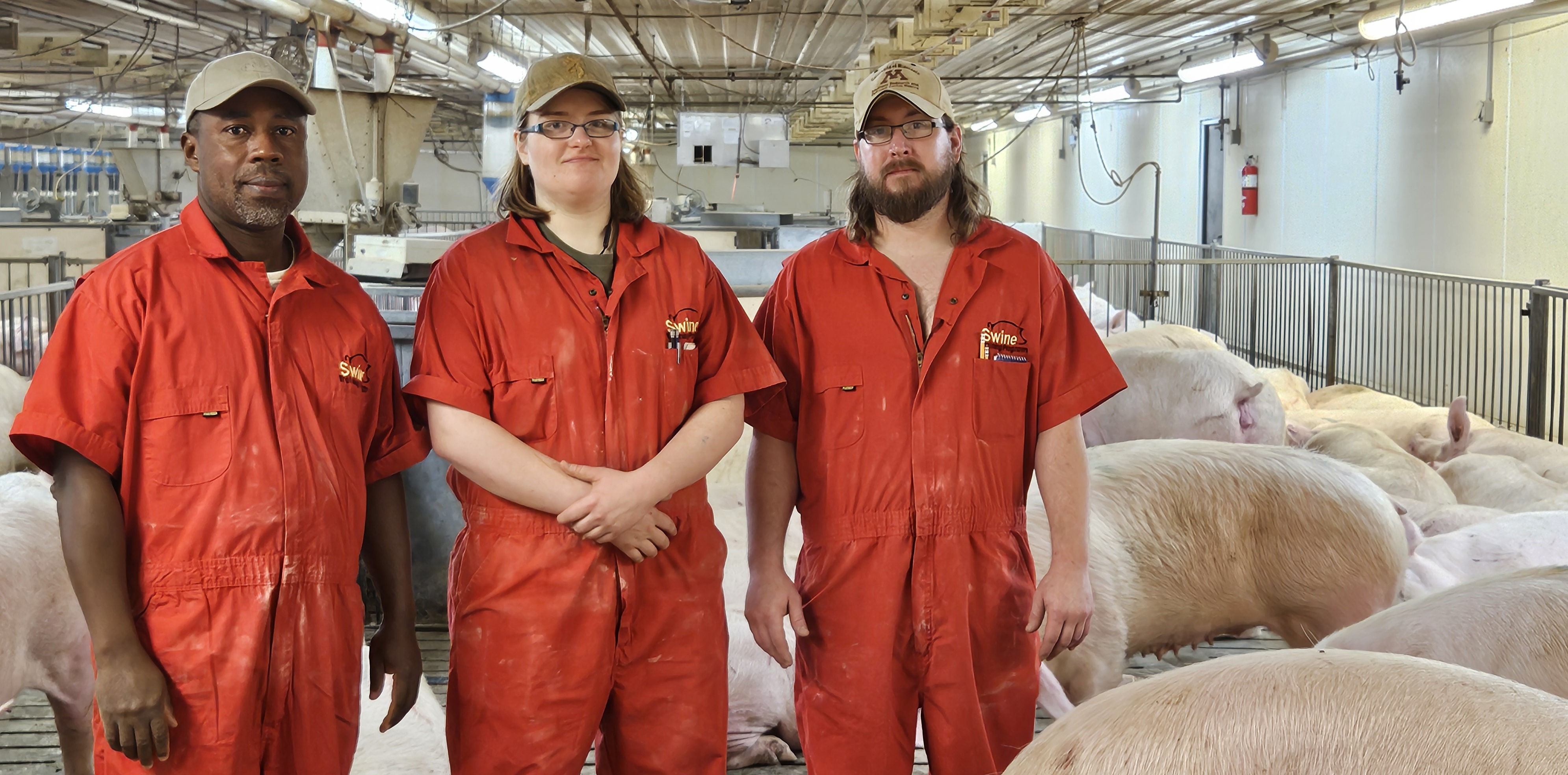 Hayford Manu, Kayla Corneliussen, and Dustin Gerdts standing in the group housing pens at SROC.